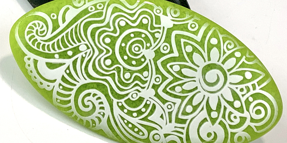 Detail of a lid of a glass box, sandblasted with a floral/paisley pattern.